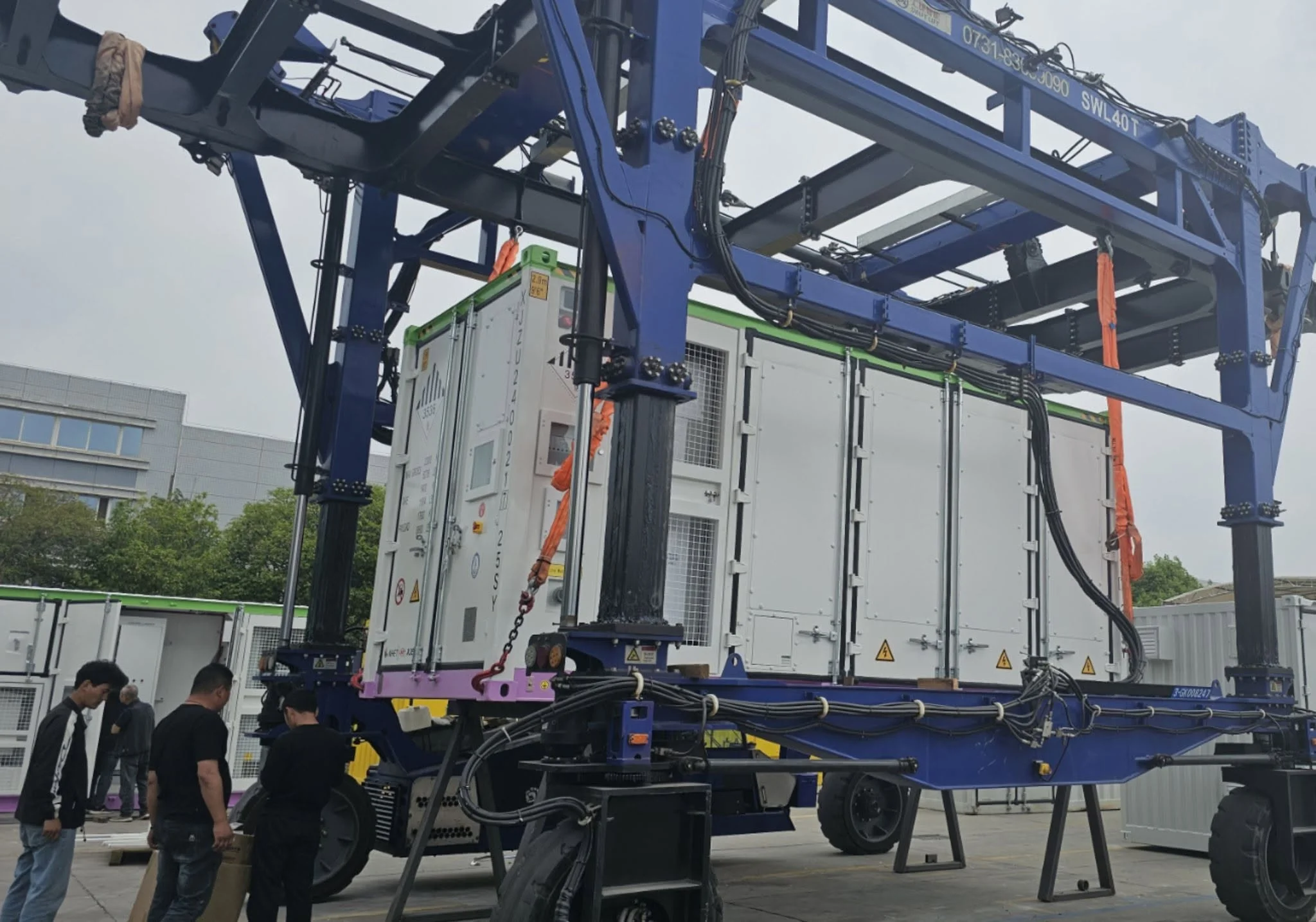 Containerised BESS unit lifted by crane on an industrial site