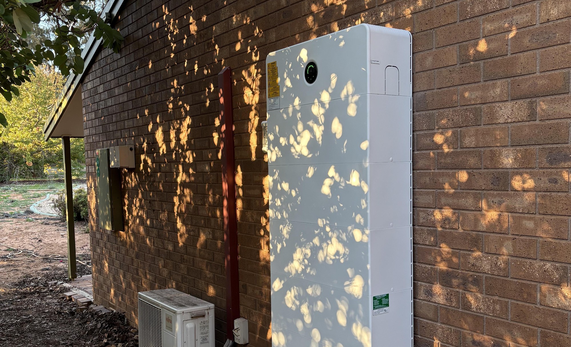 Ein GoodWe-Batteriespeicher und Hybrid-Wechselrichter montiert an der Außenwand eines Hauses